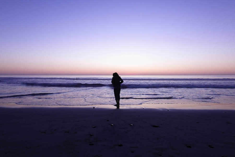 Lone woman on a beach thinking